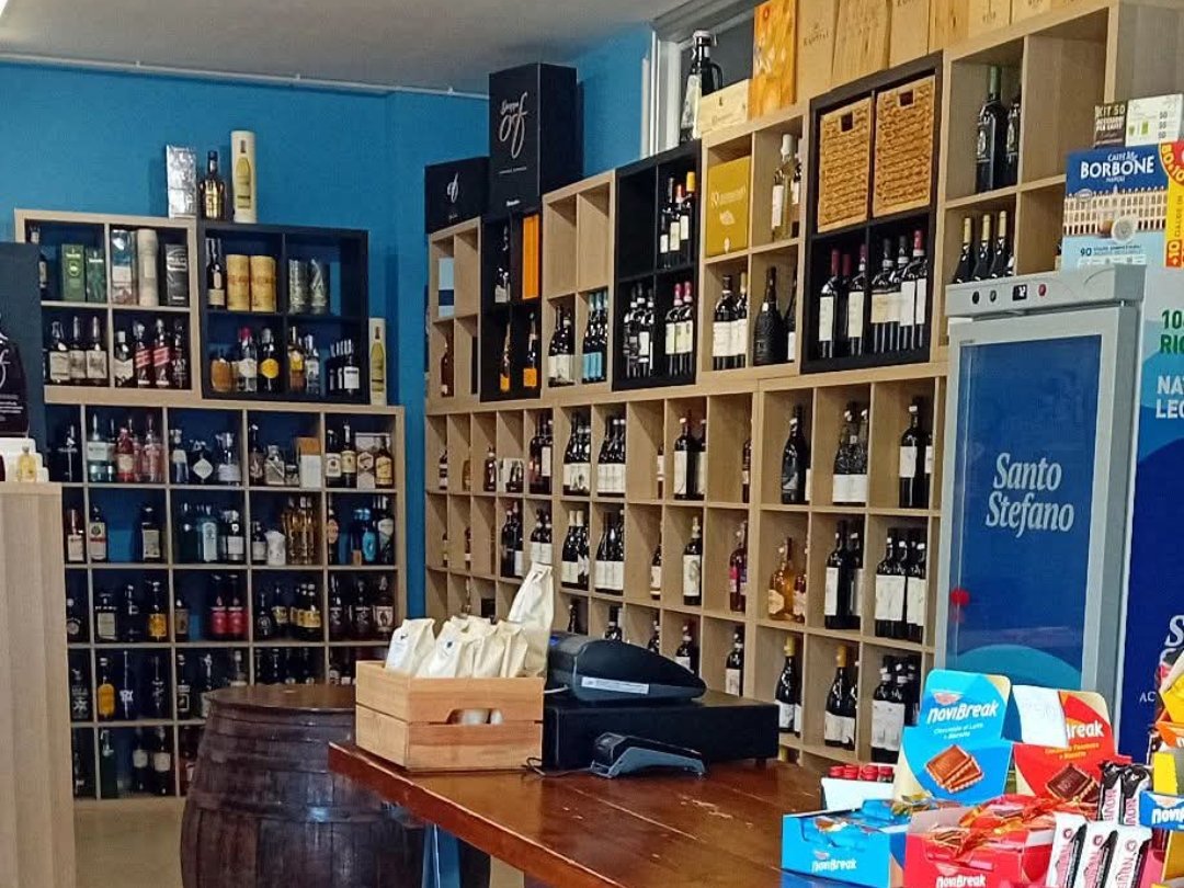 L’interno della bottega Il Bibitaio: scaffali di vini e distillati, la botte e il banco